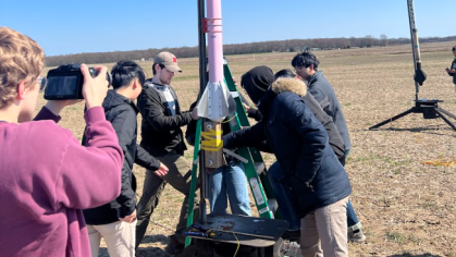 The AIAA Rutgers Rocket Propulsion Lab working on a small rocket outside