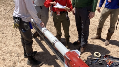 Rutgers students working on a rocket outside