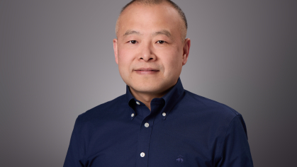 Headshot of male with dark blue button down dress shirt.