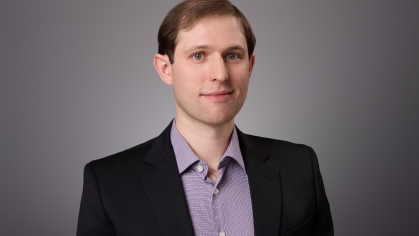 headshot of man with grey shirt and black jacket