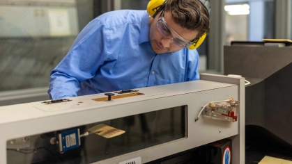 Wearing earmuffs and safety glasses, Rutgers-New Brunswick senior Doug Doyle operates and miniature wind tunnel in a School of Engineering lab on Busch campus.