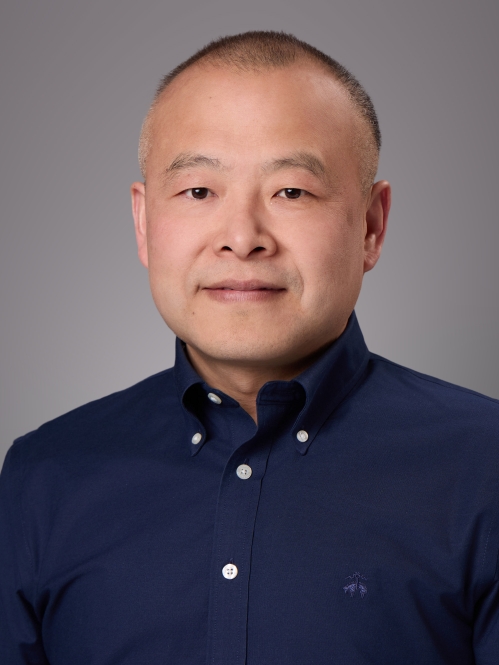 Headshot of male with dark blue button down dress shirt.