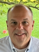 man in front of tree branch and green grass