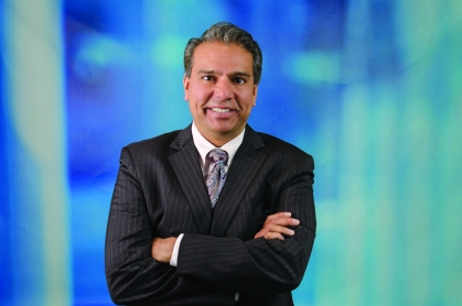 Headshot of white male wearing a suit and tie with his arms crossed.