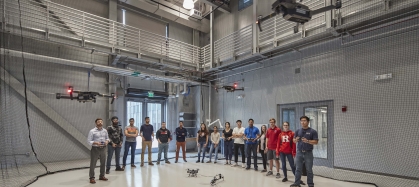 Large group of students with their professor flying drones in a drone lab