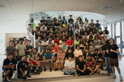 group of students sitting on and standing around a staircase