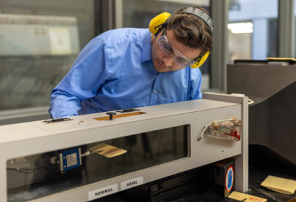 man with yellow head phones and blur shirt using machine