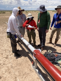 Rutgers students working on a rocket outside