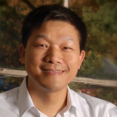 Headshot of male with short black hair.